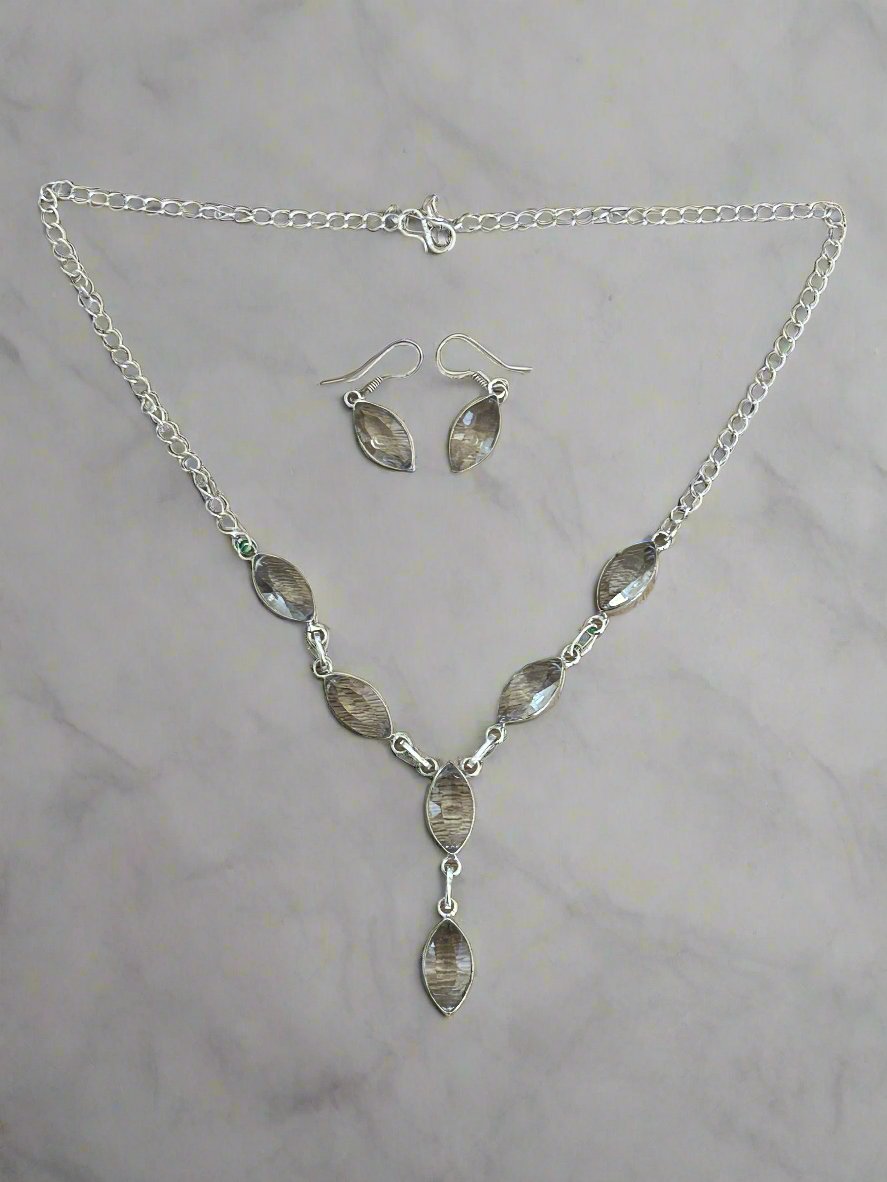 Whie topaz and 925 sterling silver necklace and earring set. the necklace features 6 faceted white topaz gems and the earrings have one whte topaz each