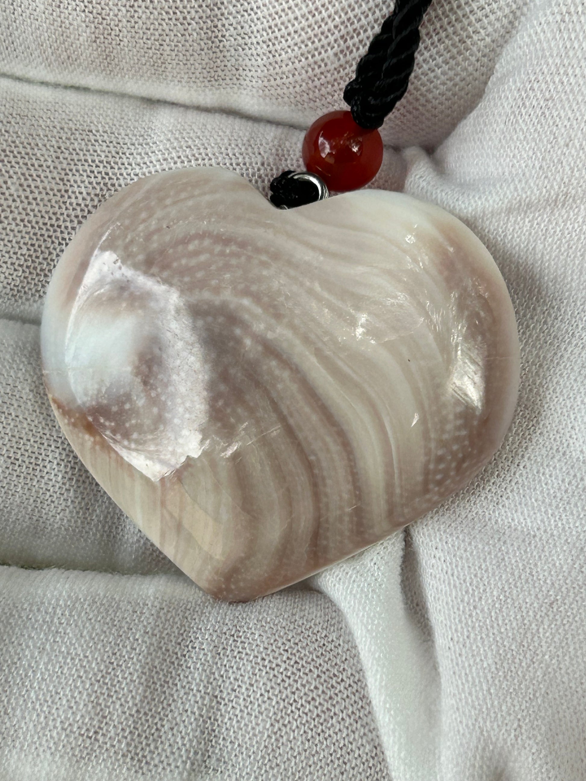 heart shaped shell pendant with brown and white swirl and black cord necklace