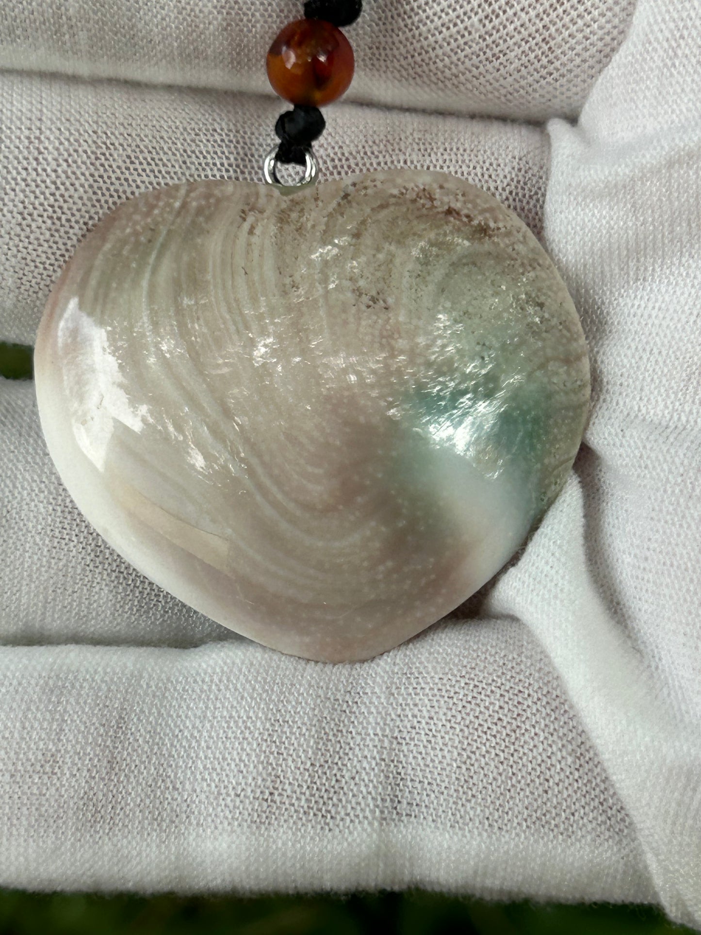 heart shaped shell pendant with brown cream white green swirl and black cord necklace