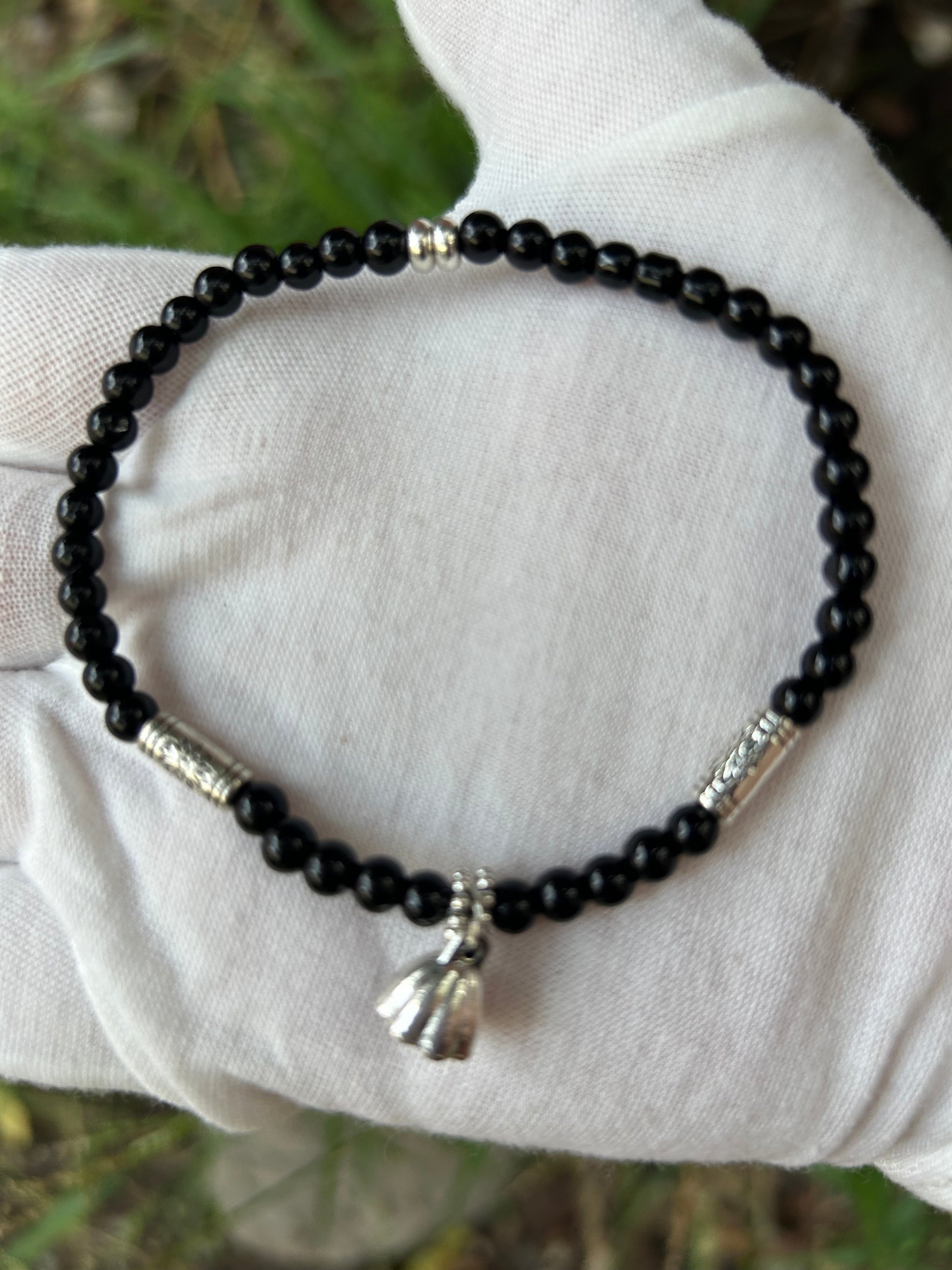 black onyx round bead bracelet with ornate silver detail and silver charm