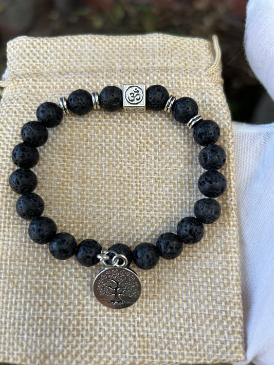 lava rock bead bracelet with silver detail om symbol and round tree of life charm on hessian jewellery bag