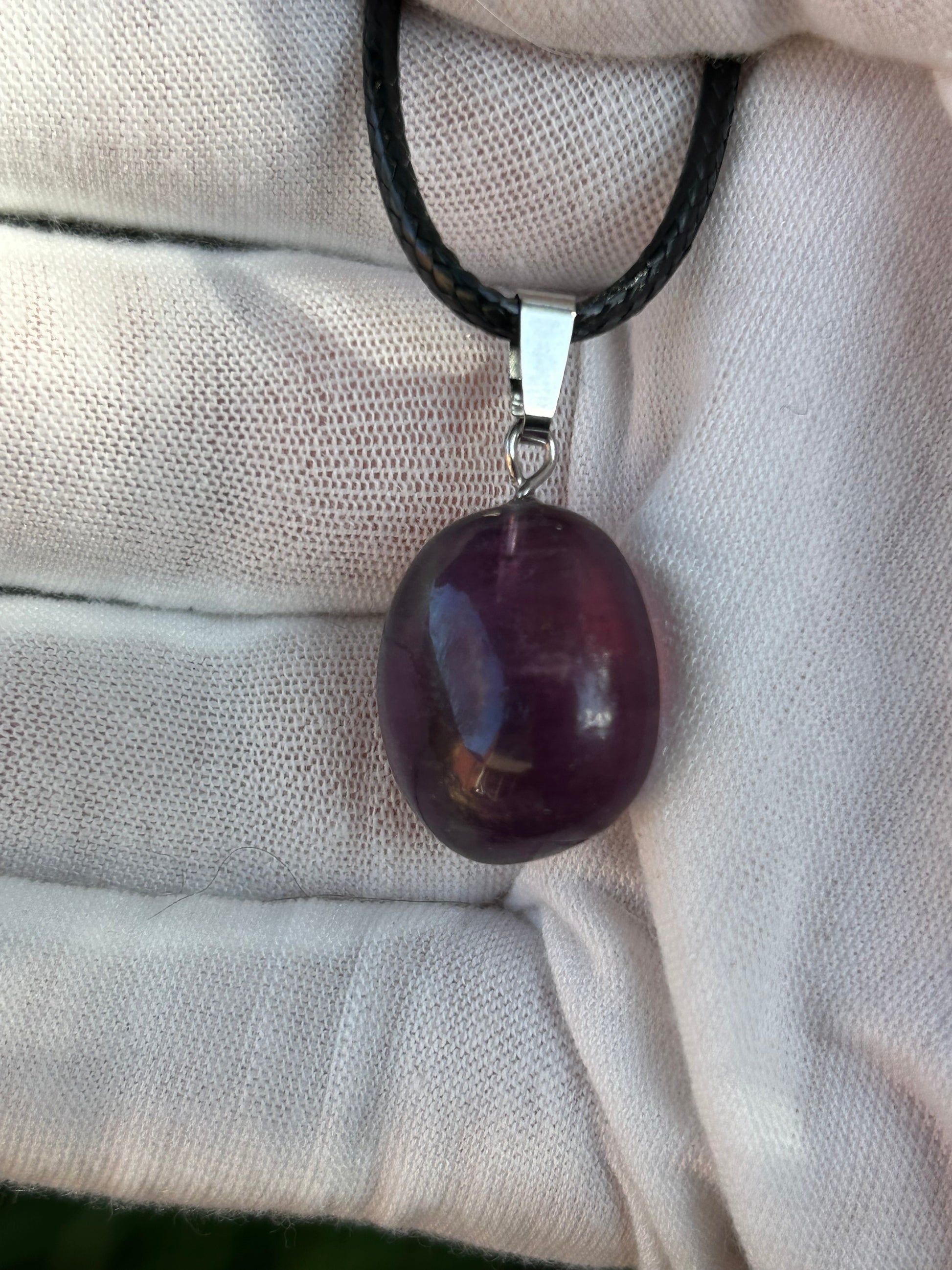 small purple fluorite irregular shape polished pendant with silver pendant attachment and black cord necklace