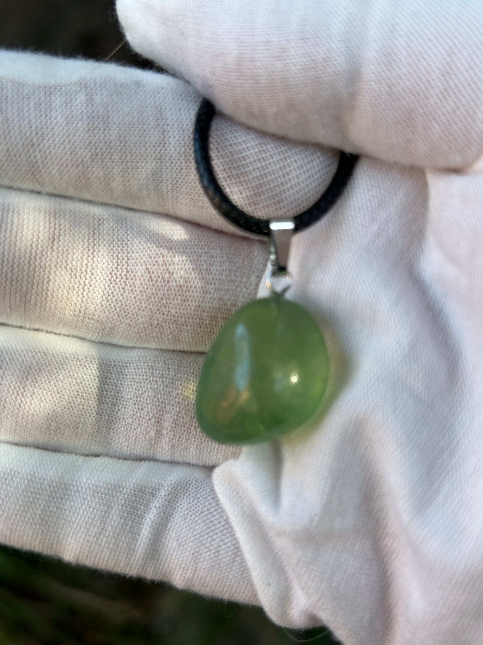 small green fluorite irregular shape polished pendant with silver pendant attachment and black cord necklace