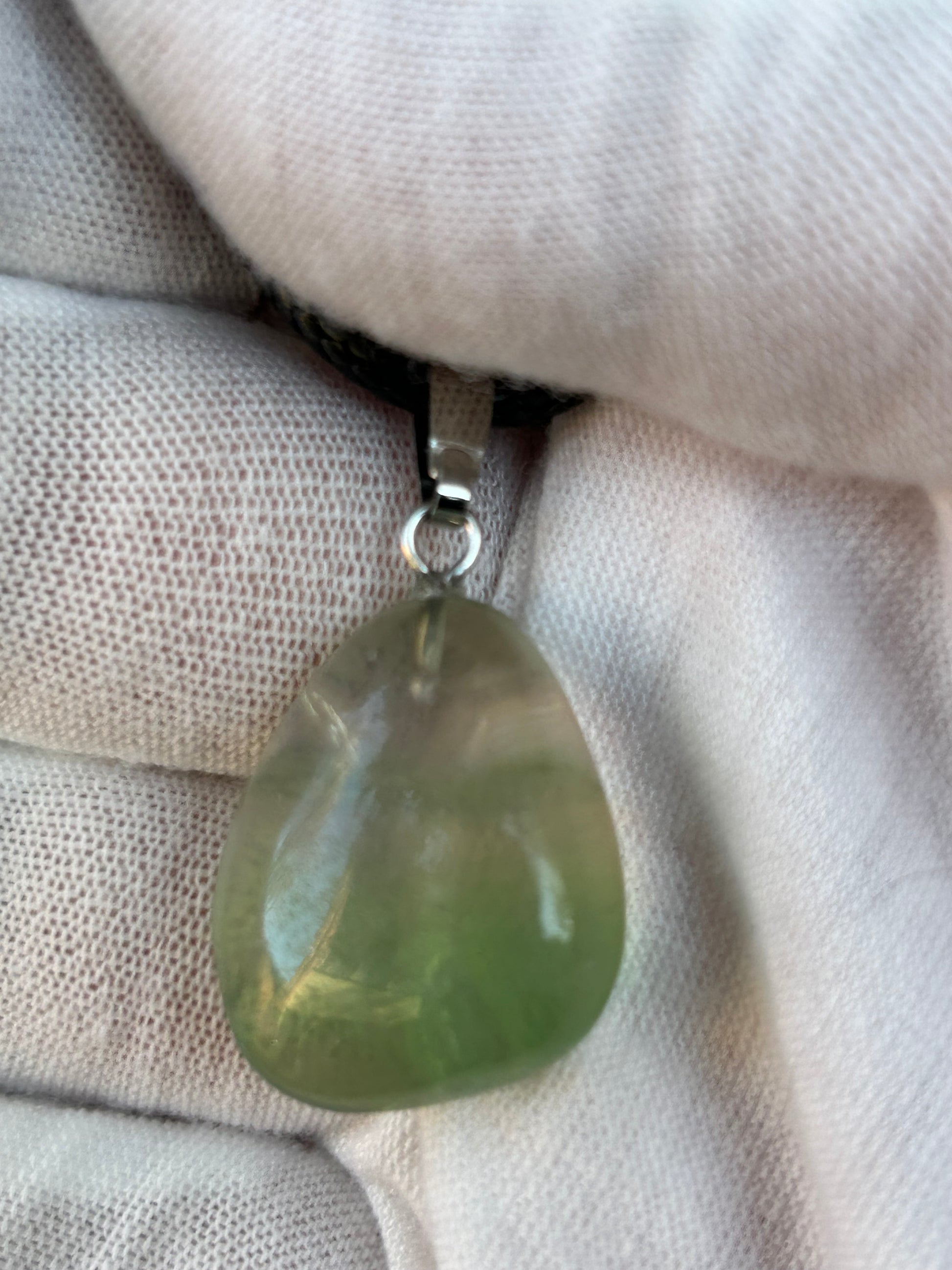small green fluorite irregular shape polished pendant with silver pendant attachment and black cord necklace