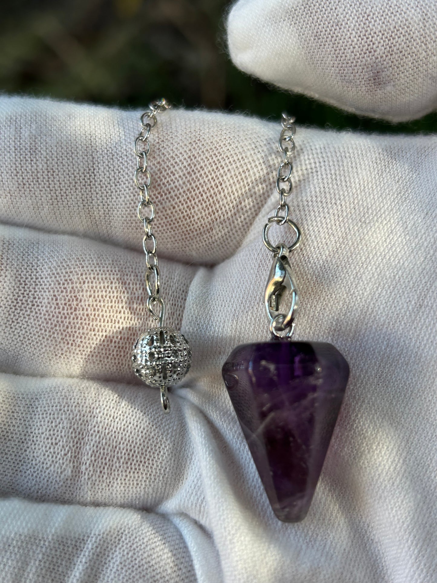 Polished amethyst crystal point pendulum on silver chain