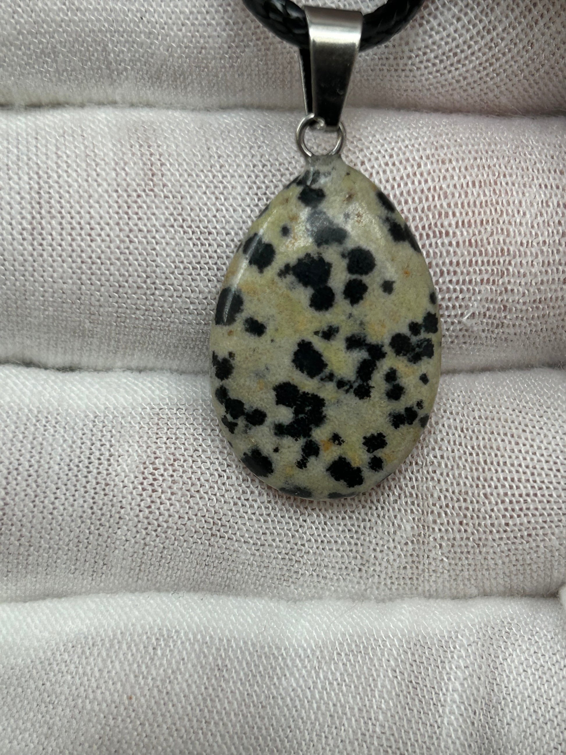 Dalmatian Jasper polished tear drop waterdrop pendant with silver attachment and black cord neck.ace