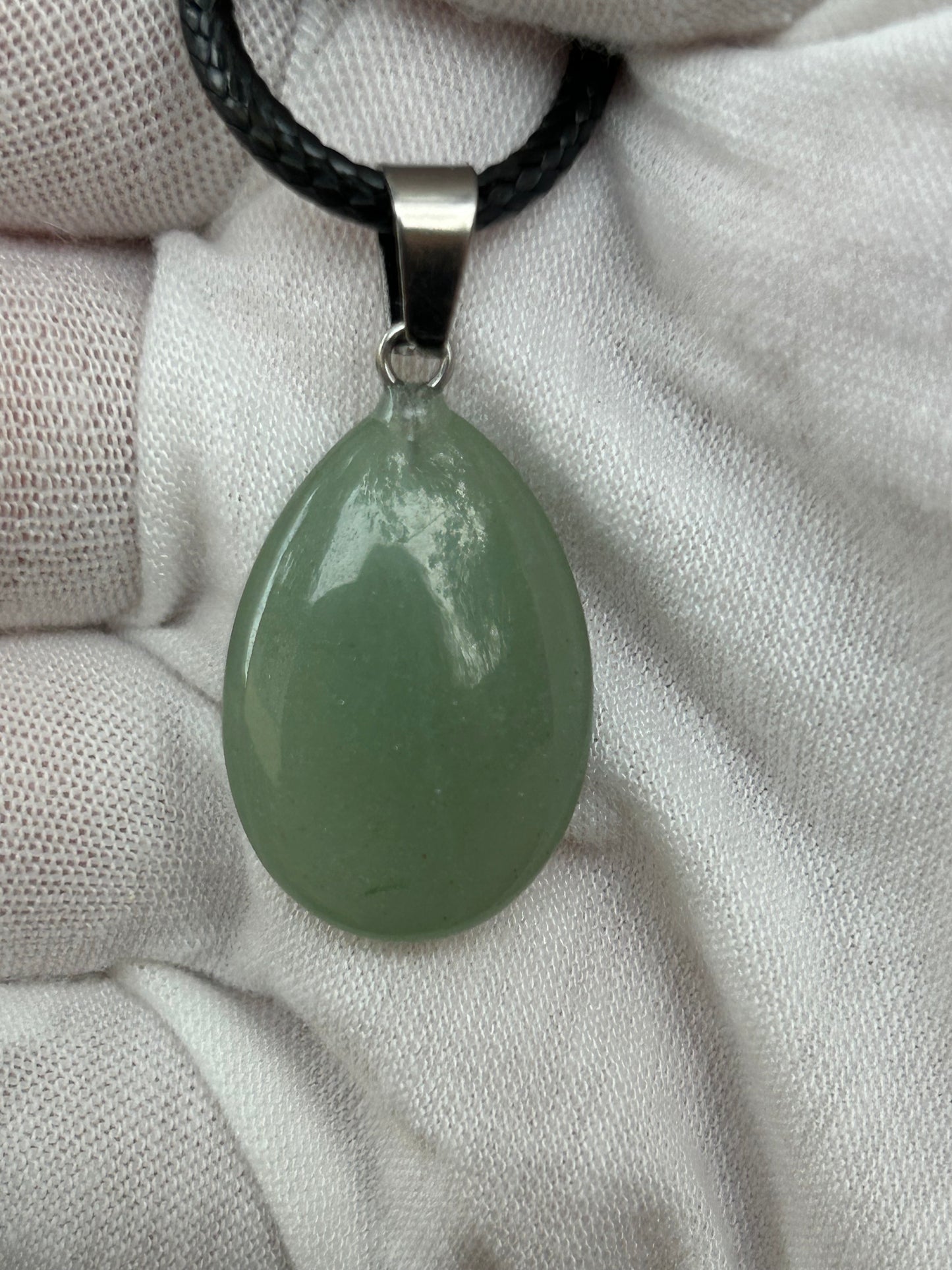 green aventurine crystal polished raindrop teardrop shaped pendant with silver attachment and black cord necklace