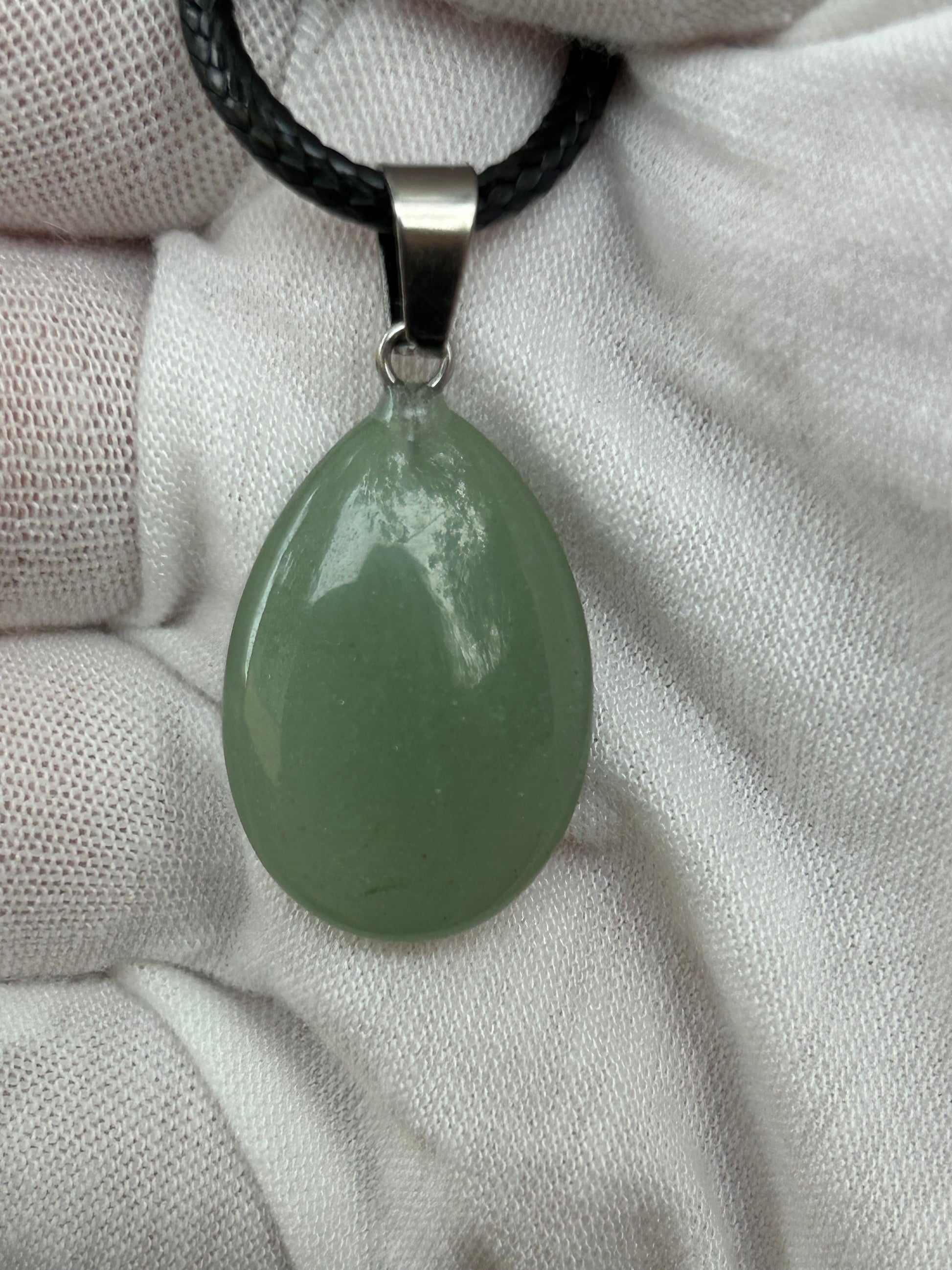 green aventurine crystal polished raindrop teardrop shaped pendant with silver attachment and black cord necklace