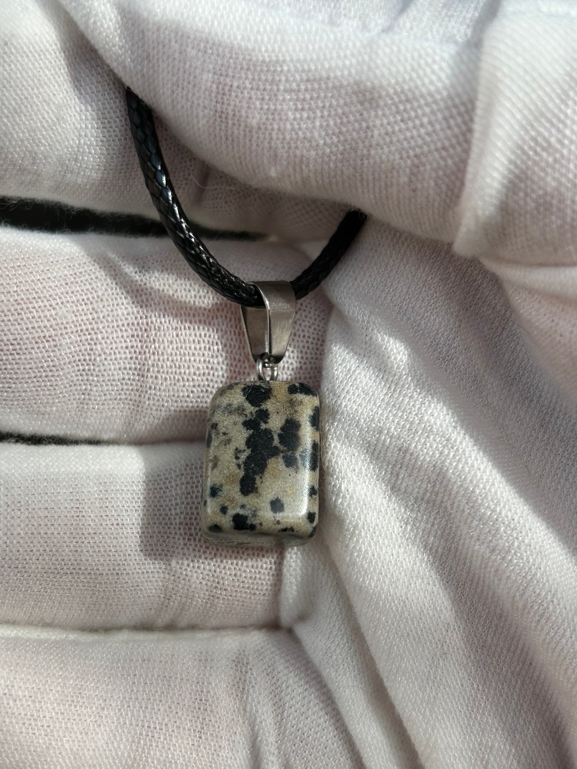 Small dalmatian jasper square polished pendant with silver attachment and black cord necklace