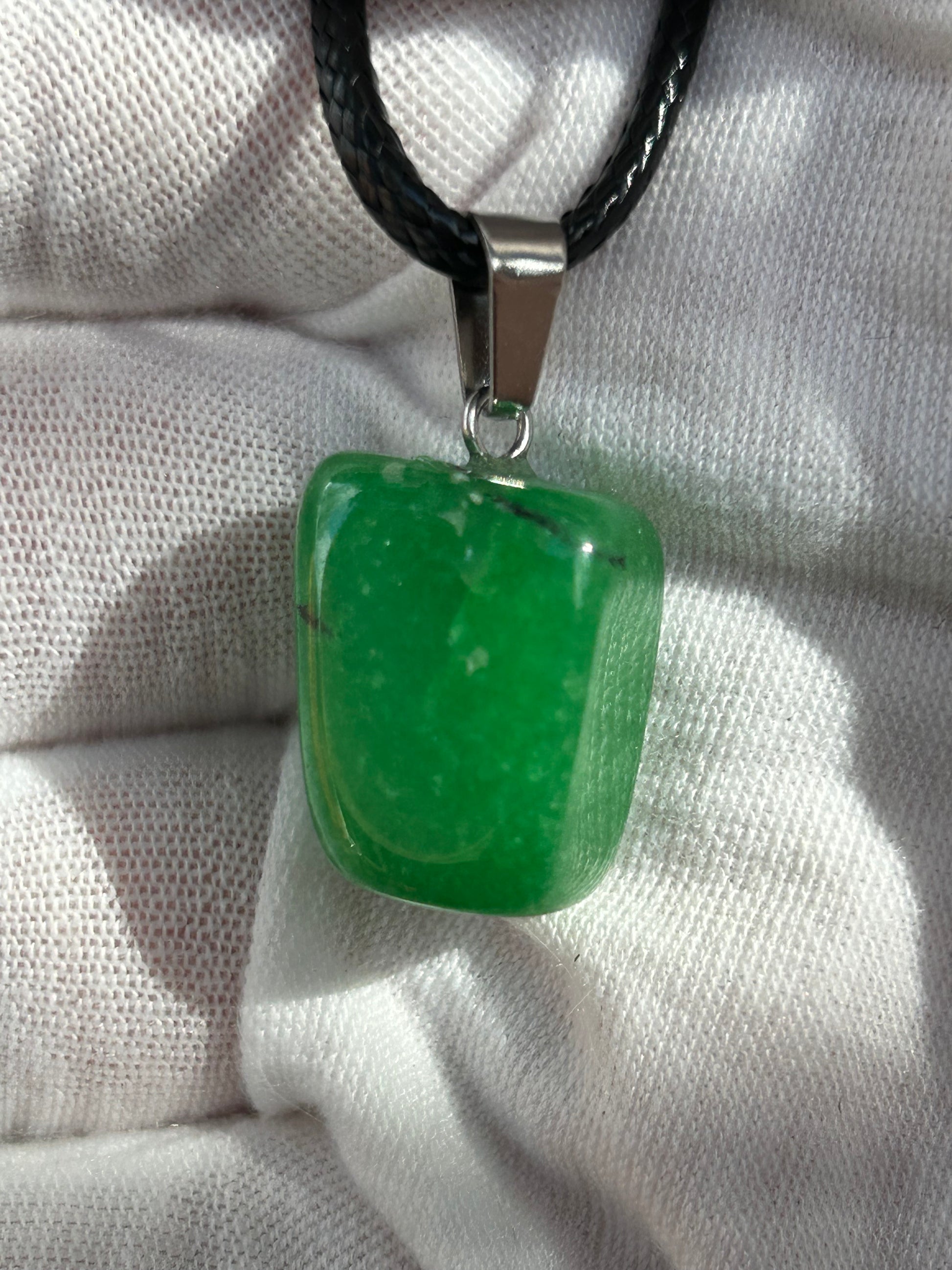 small green agate crystal polished irregular shaped pendant with silver pendant attachment and black cord necklace