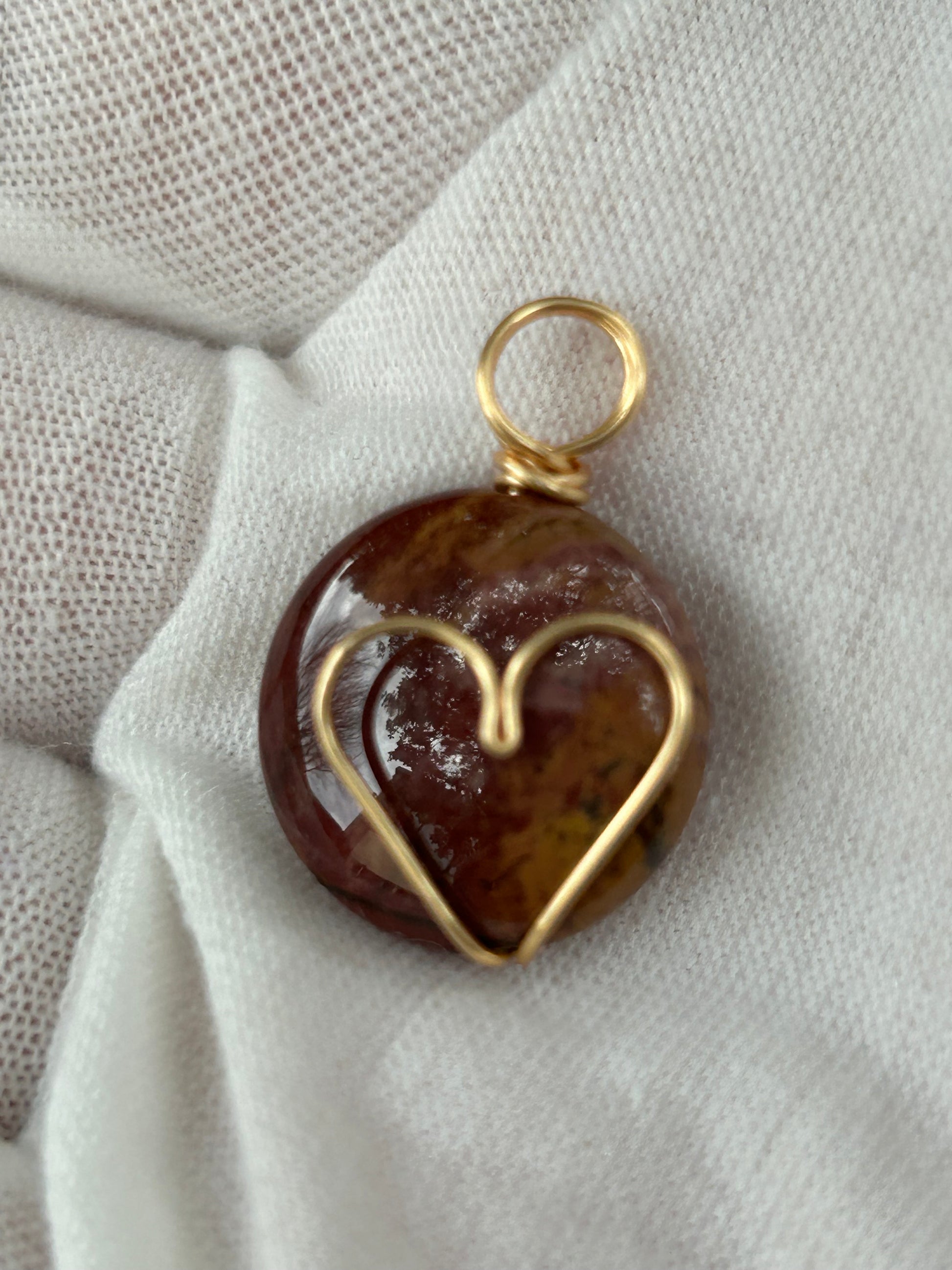 Small round red jasper polished pendant or charm with wire wrapped gold heart