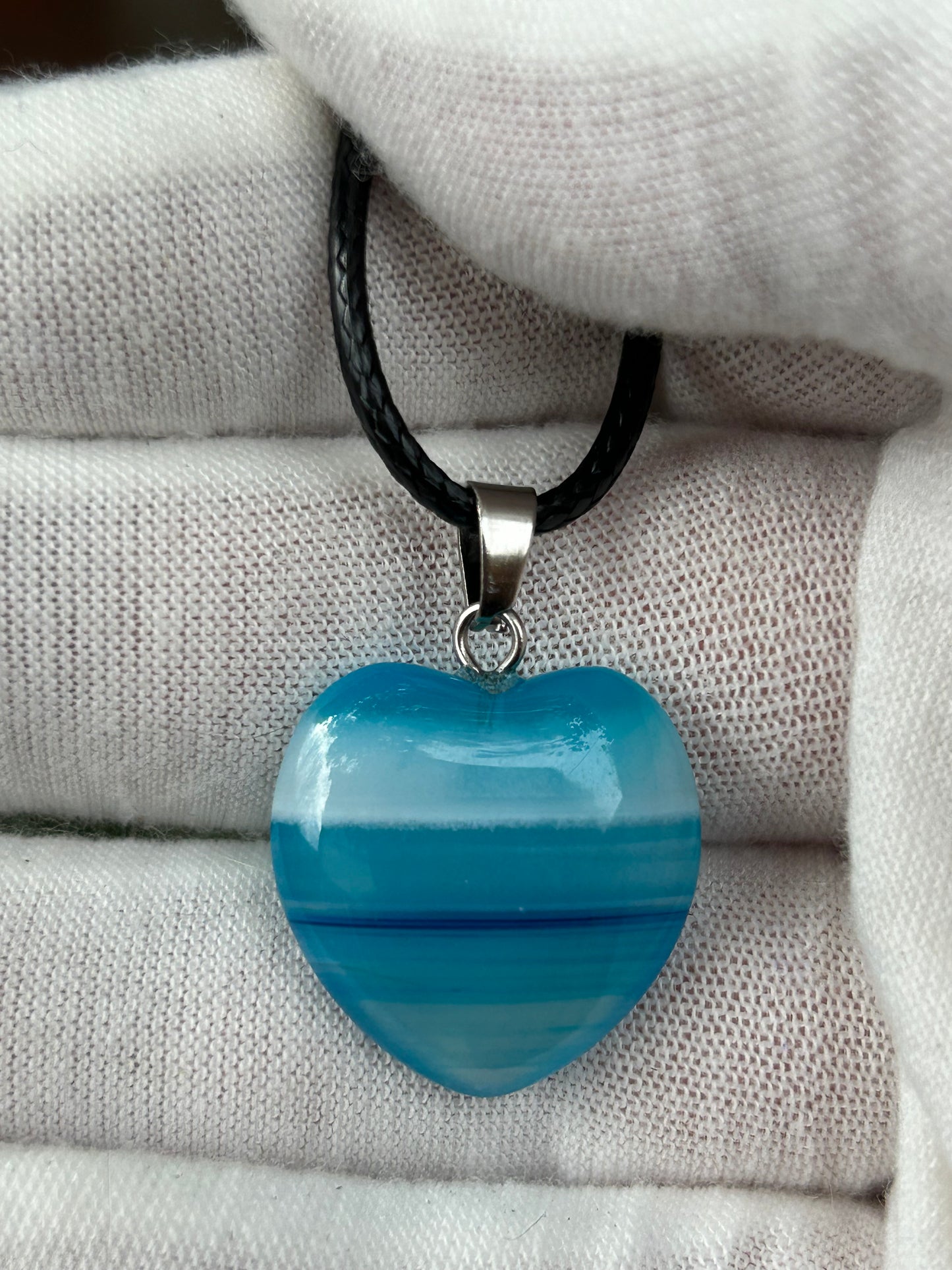 Blue horizontal striped agate polished crystal heart shaped pendant with silver pendant connector black cord necklace
