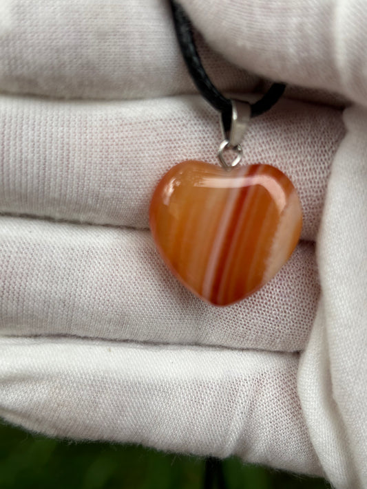 Striped Orange Agate Polished Heart Pendant with silver pendant attachment and black cord necklace