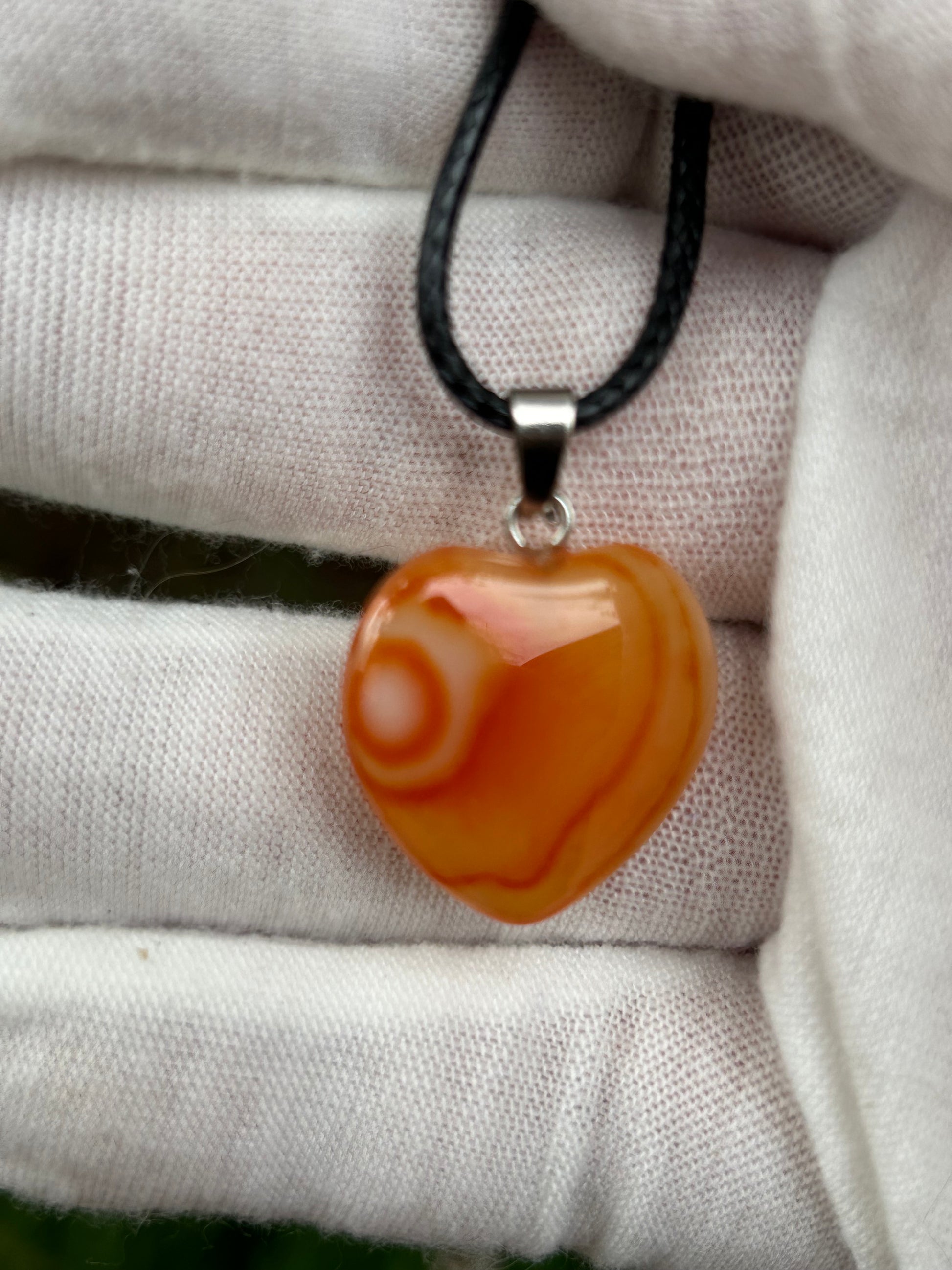 Orange Agate Polished Heart Pendant with silver pendant attachment and black cord necklace