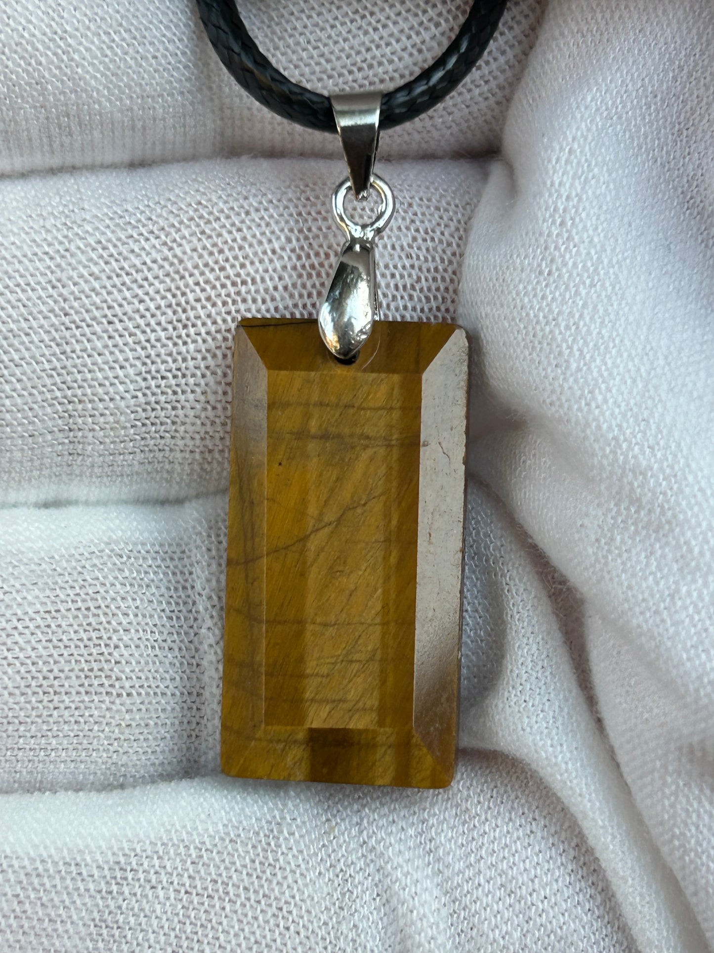 Tigers eye polished rectangular pendant with silver pendant attachment and black cord necklace