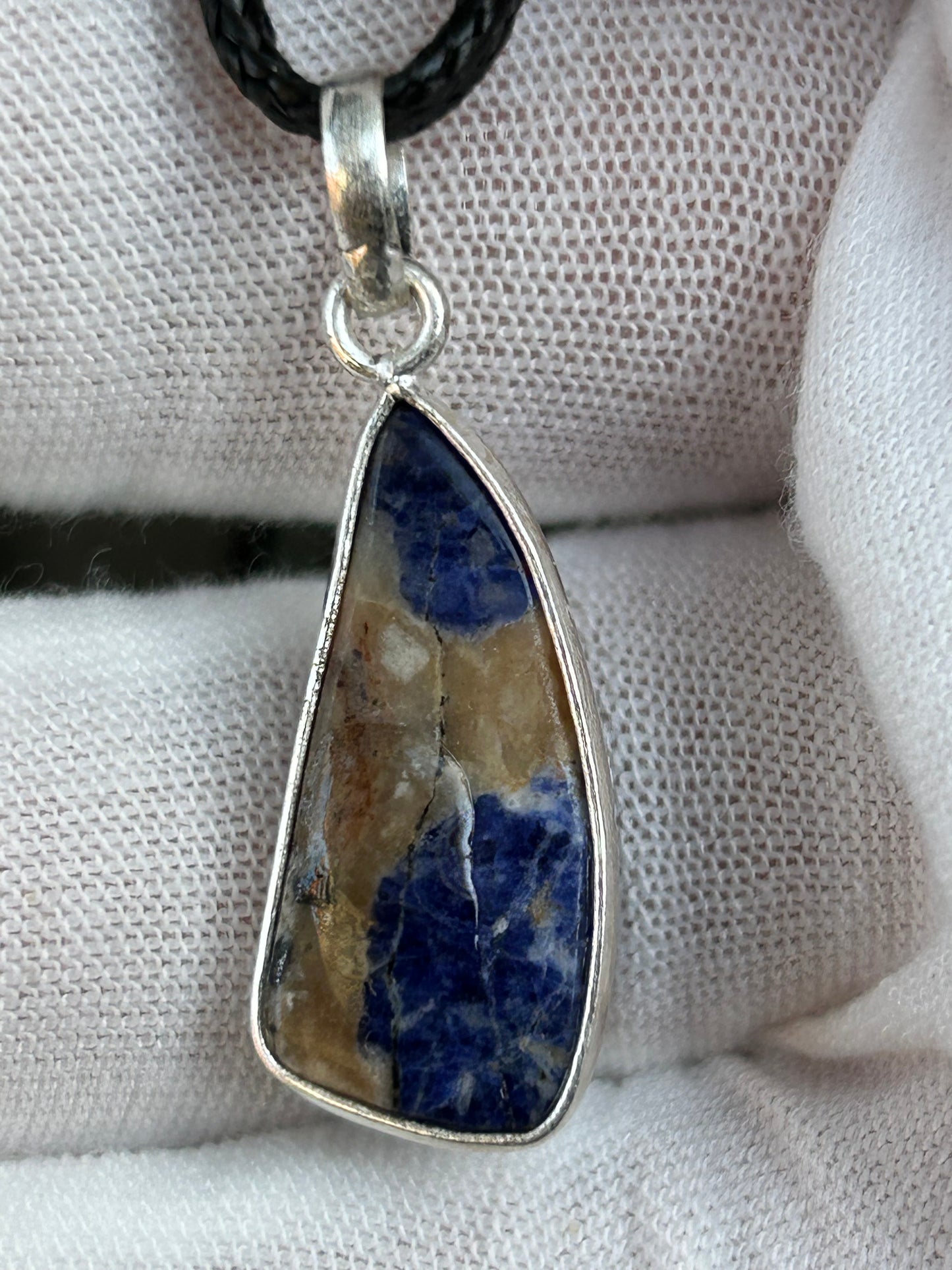 Sodalite blue cream brown pendant set in sterling silver with black cord necklace