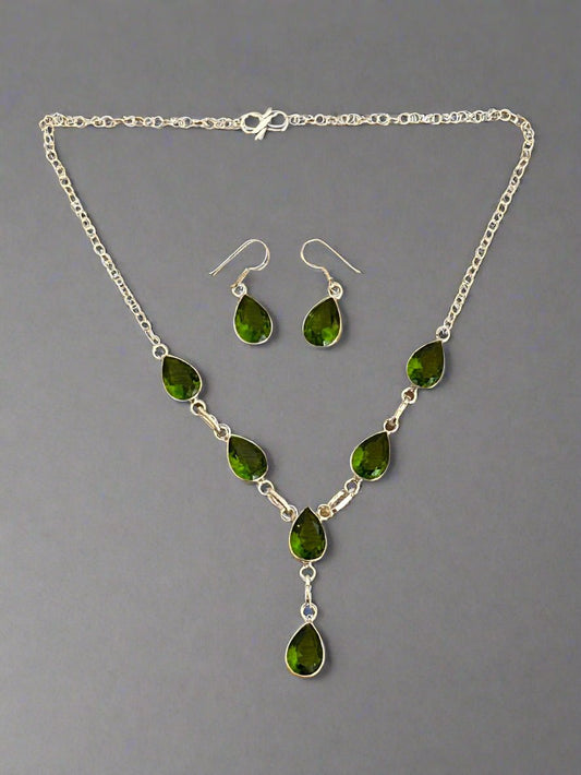 Green Peridot and 925 Sterling Earrings and and Necklace Set. The necklace has 6 faceted peridot gems  cut in a water drop shape and the earrings each have one gem