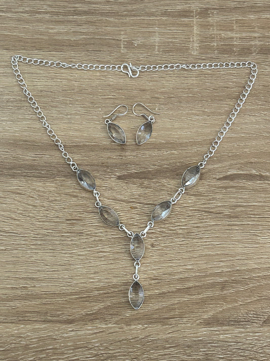 Whie topaz and 925 sterling silver necklace and earring set. the necklace features 6 faceted white topaz gems and the earrings have one whte topaz each