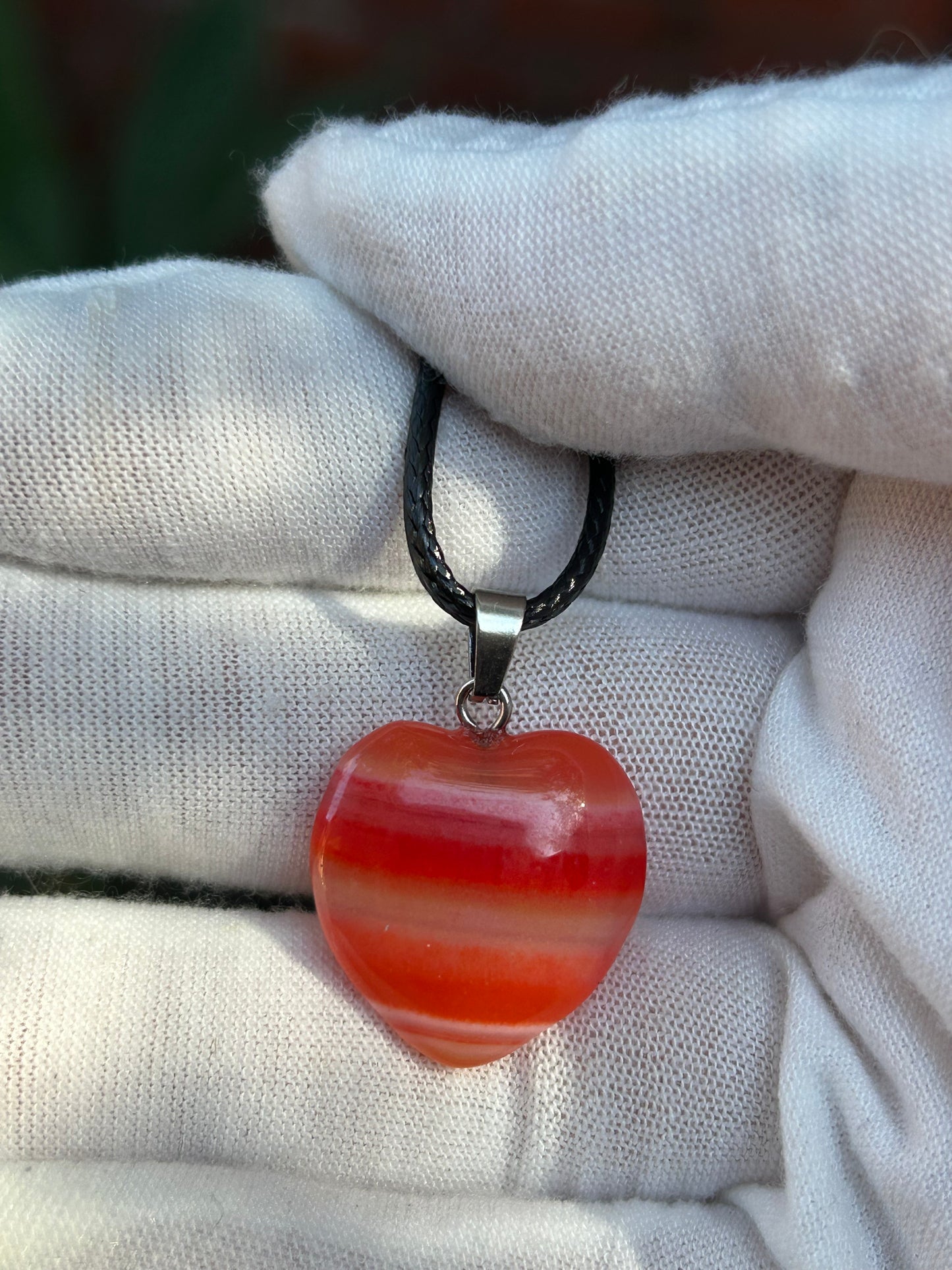 Red agate polished heart pendant with silver pendant attachment and black cord necklace