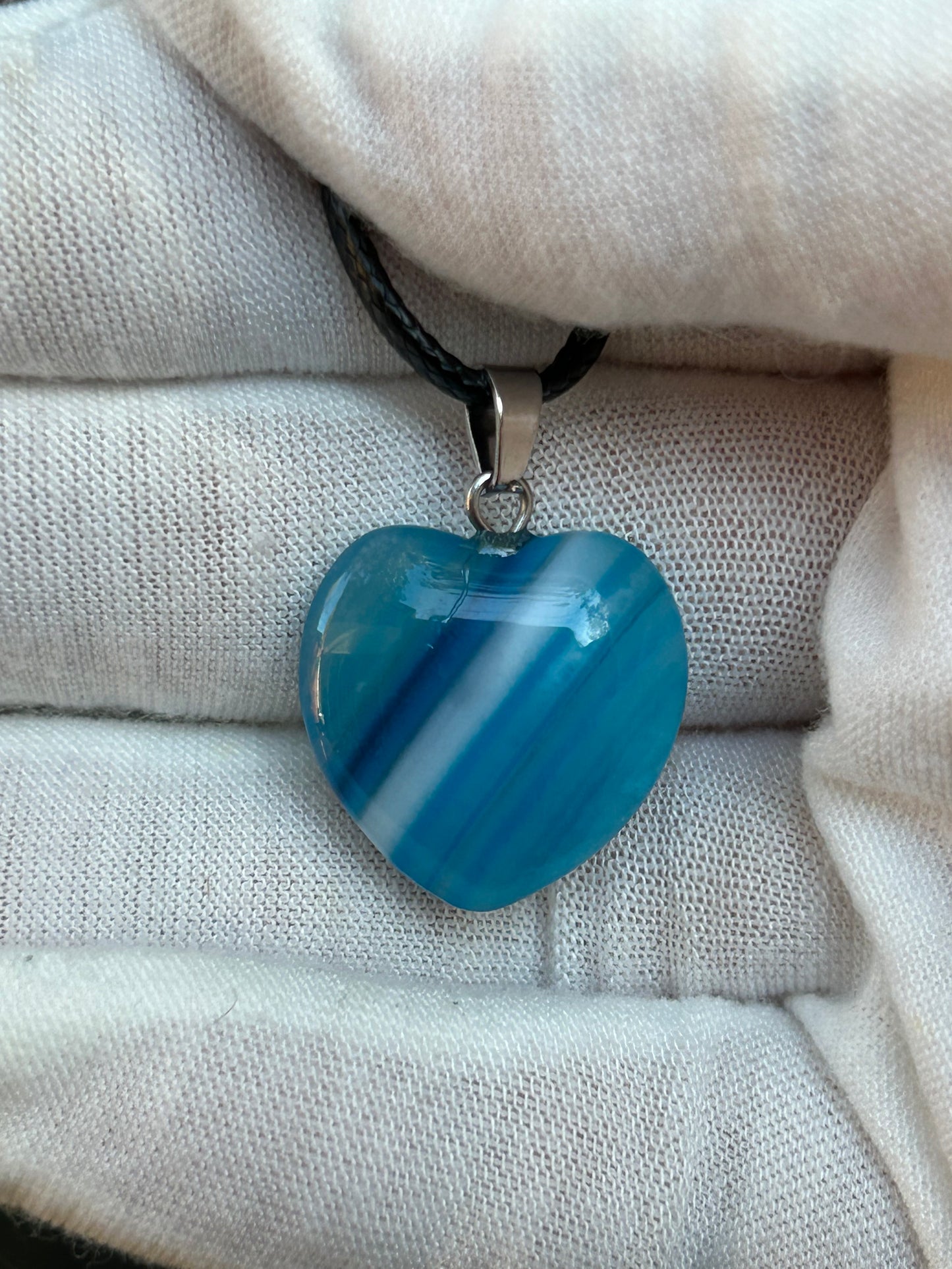 Blue agate polished heart pendant with silver pendant attachment and black cord necklace