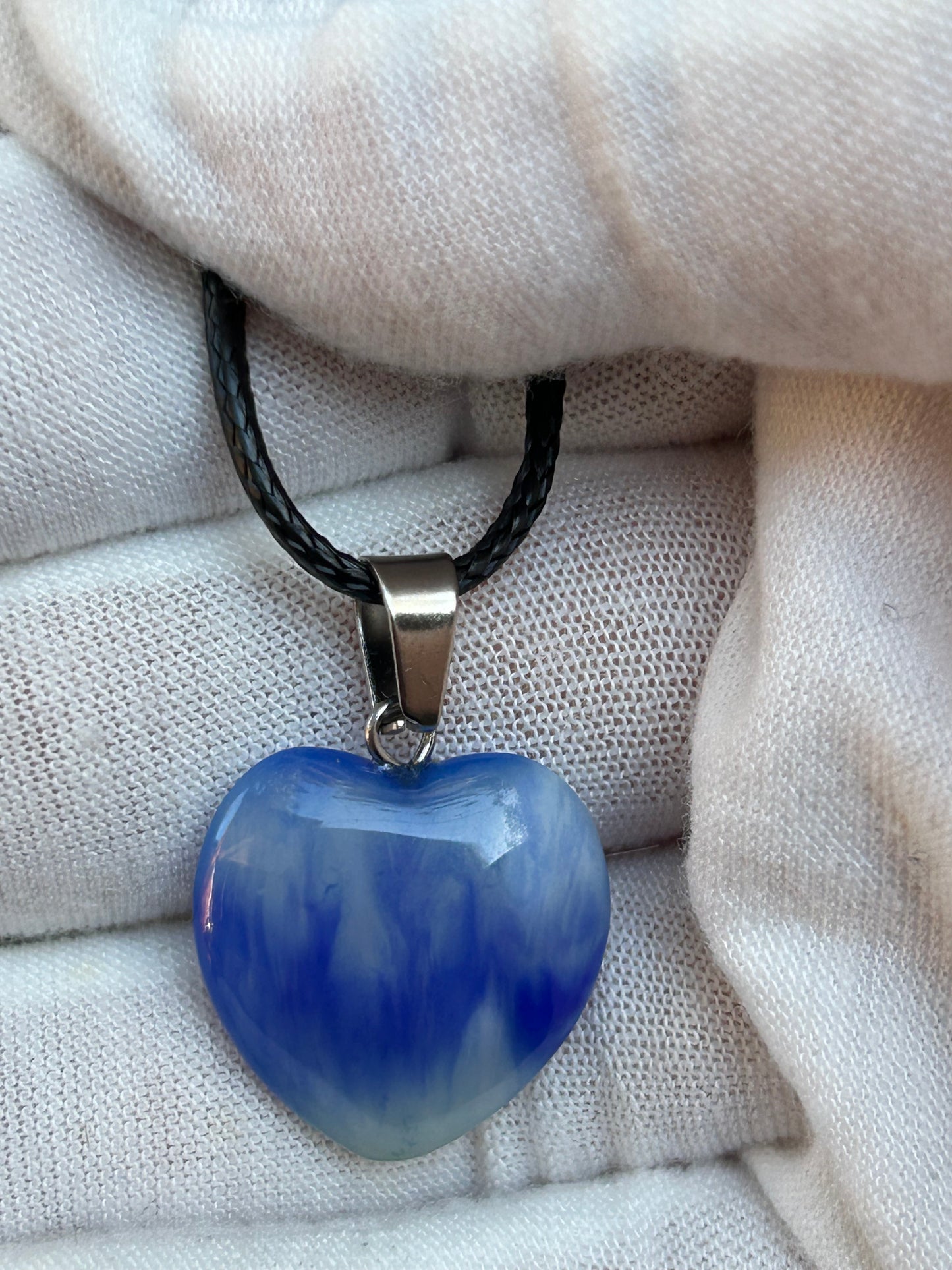 Blue agate polished heart pendant with silver pendant attachment and black cord necklace