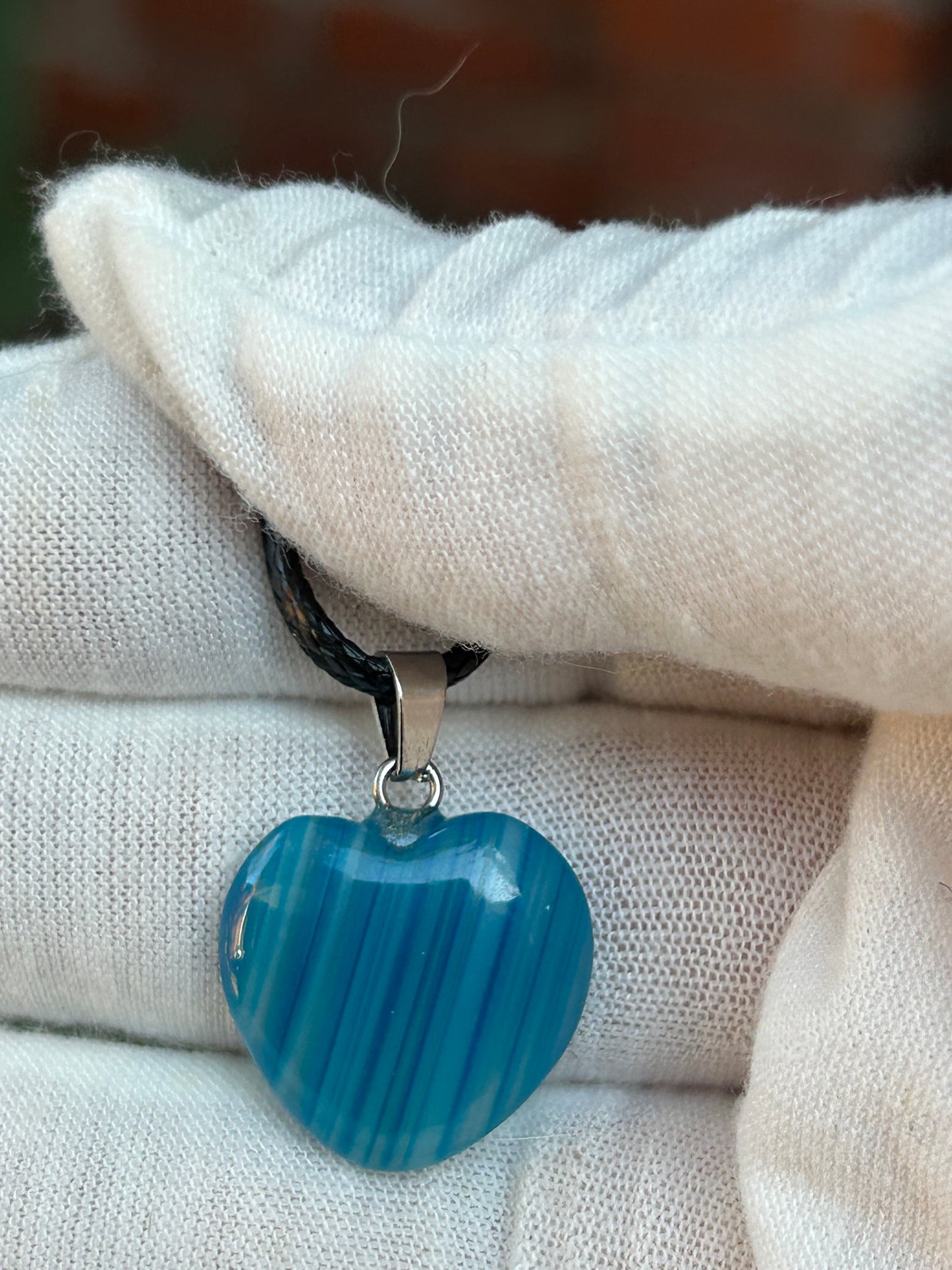 Blue agate polished heart pendant with silver pendant attachment and black cord necklace