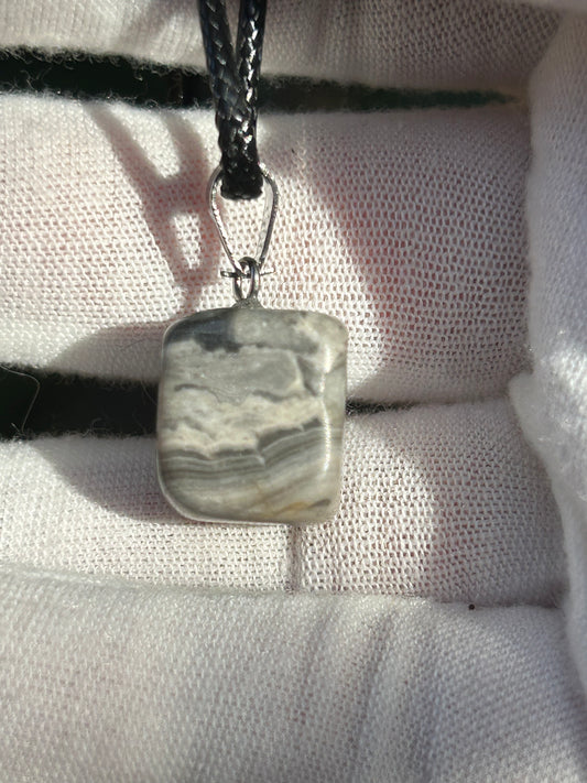 Crazy Lace Agate Polished Stone Pendant. Grey Tones with a silver pendant attachment and black cord necklace