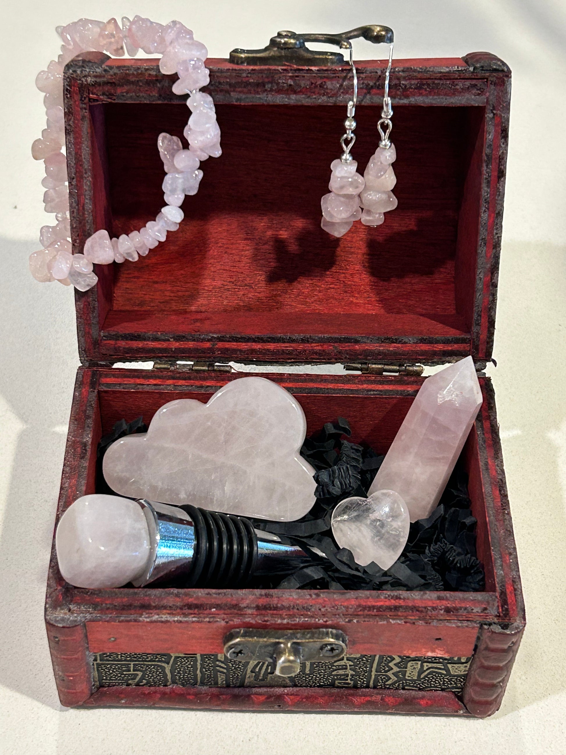 wooden treasure chest contains a collection of Rose Quartz pieces to create an aura of self love.