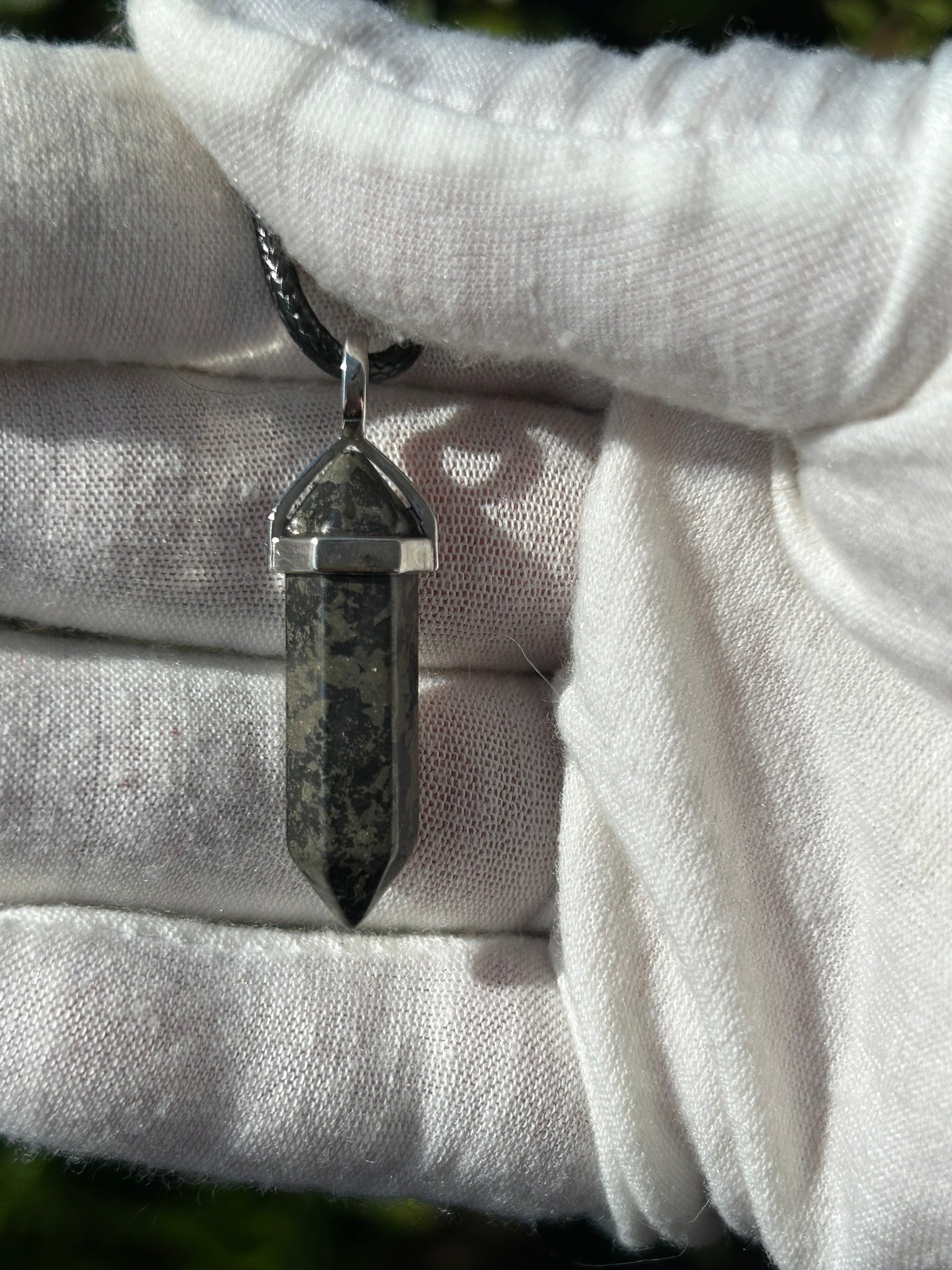 Pyrite point pendant with silver setting and black cord necklace